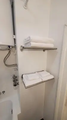 a bathroom with white towels on a shelf next to a sink at Yes Apartment, Belgrade Center in Belgrade