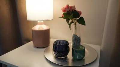 a table with a vase with a flower and a lamp at Yes Apartment, Belgrade Center in Belgrade