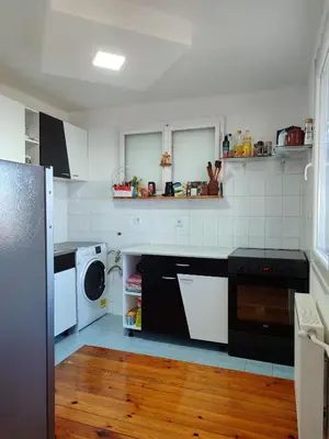 a kitchen with white appliances and a wooden floor at House 33 in Stari Slankamen