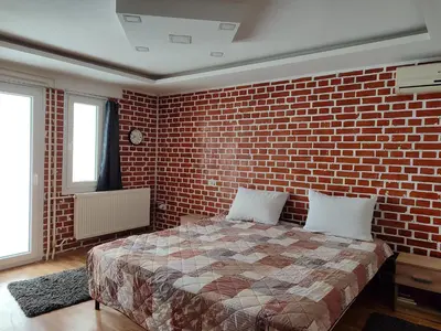 a bedroom with a brick wall and a bed at House 33 in Stari Slankamen