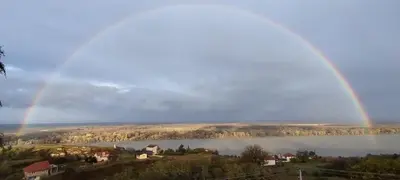 a rainbow over a lake with houses and buildings at House 33 in Stari Slankamen