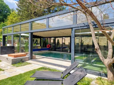 a glass house with a pool and two chairs at Vila MP Banstol 4*- Brdež do, Fruška gora in Inđija