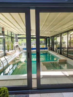 a swimming pool seen through the windows of a building at Vila MP Banstol 4*- Brdež do, Fruška gora in Inđija