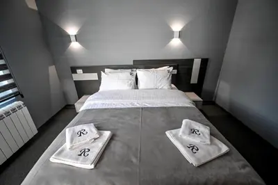 a bedroom with a large bed with two towels on it at Respect034 in Arandjelovac