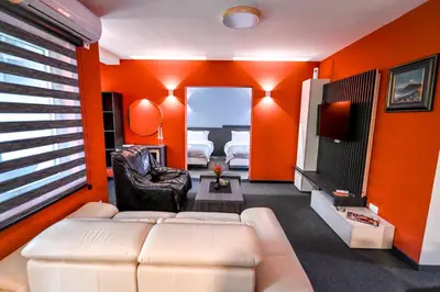 a living room with orange walls and a couch and a tv at Respect034 in Arandjelovac