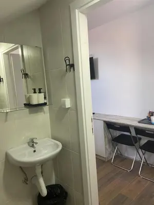 a bathroom with a white sink and a counter at OMIS Rooms in Pančevo