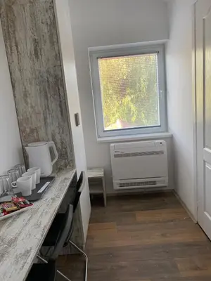a room with a desk with a window and a radiator at OMIS Rooms in Pančevo