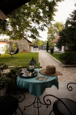 a table with a hat sitting on a patio at Vila Lio & Restaurant Devojacki Bunar in Novi Vladimirovac