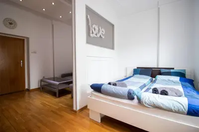 a bedroom with a bed with blue pillows on it at Apartman Obilic in Belgrade