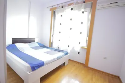 a bedroom with a bed and a window at Apartman Obilic in Belgrade