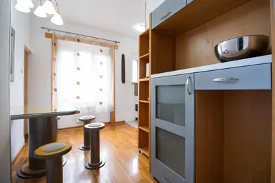a kitchen with a counter and a table and stools at Apartman Obilic in Belgrade