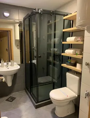 a bathroom with a shower and a toilet and a sink at Apartman Ambasador in Pančevo