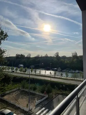 a view of a river with the sun in the sky at Apartman Ambasador in Pančevo