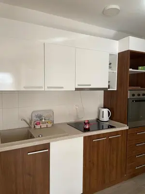 a kitchen with white cabinets and a counter top at Apartman Ambasador in Pančevo