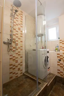 a bathroom with a shower with a washing machine at Top Spot apartment in Belgrade