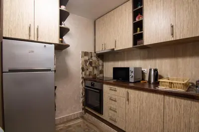 a kitchen with wooden cabinets and a refrigerator at Top Spot apartment in Belgrade