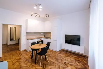 a kitchen with a table and chairs and a television at Marshal Doctor in Belgrade