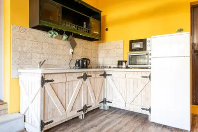a kitchen with wooden cabinets and a white refrigerator at Seosko Domaćinstvo Pustolov in Stari Banovci