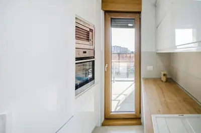 a kitchen with an oven and a door to a balcony at A blok New Belgrade 2BD in Bežanija