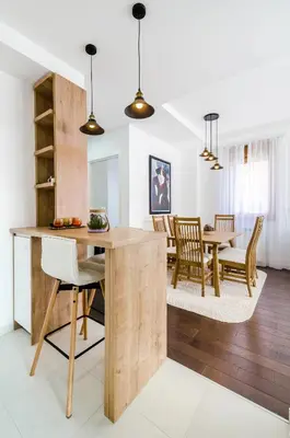 a kitchen and dining room with a wooden table and chairs at A blok New Belgrade 2BD in Bežanija