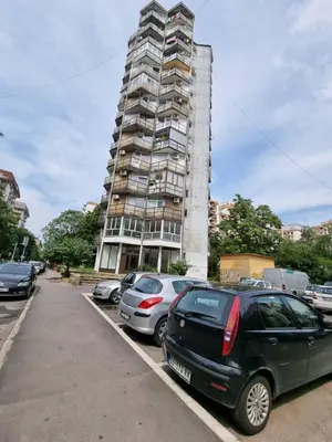 a parking lot with cars parked in front of a tall building at City View in Belgrade