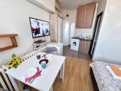a small apartment with a white table and a kitchen at City View in Belgrade