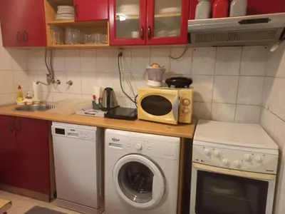 a kitchen with a washing machine and a microwave at Donji Grad in Belgrade