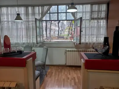 a living room with a large window and a table at Donji Grad in Belgrade