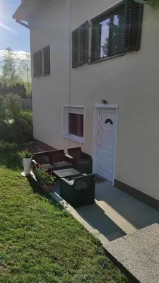 a house with a porch with a bench and a door at Andrea Airport Apartments in Belgrade