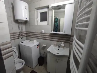 a bathroom with a sink and a toilet and a mirror at Andrea Airport Apartments in Belgrade