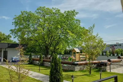 a park with a tree and a playground at Hotel GardeNN in Belgrade