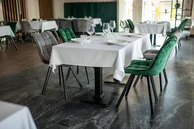 a dining room with white tables and green chairs at Hotel GardeNN in Belgrade