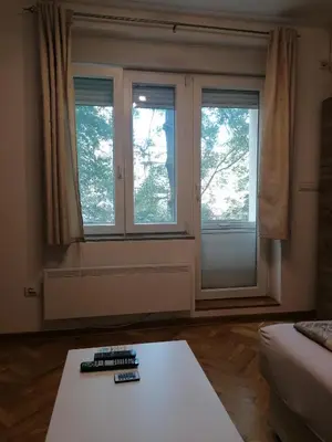 a living room with two windows and a coffee table at Natasa in Zvezdara