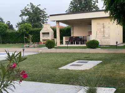 a backyard with a house with a fireplace in it at Vila Eleonora Beograd in Belgrade