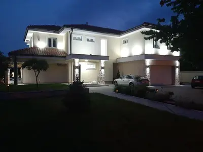 a white car parked in front of a house at night at Vila Eleonora Beograd in Belgrade