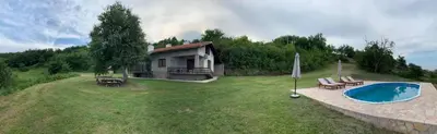 a small house with a swimming pool in the yard at Talin Raj in Arandjelovac