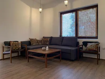 a living room with a blue couch and a table at Talin Raj in Arandjelovac
