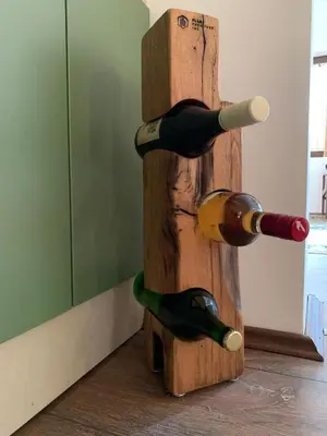 three wine bottles on a wooden wine rack at Talin Raj in Arandjelovac