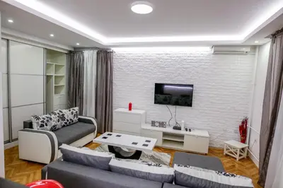 a living room with a couch and a tv on a brick wall at Silver in Žarkovo
