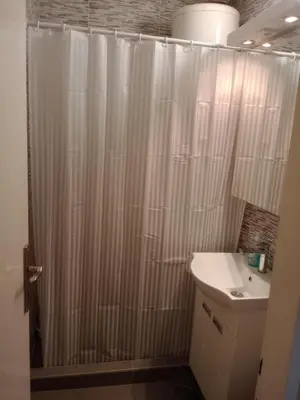 a bathroom with a shower curtain and a sink at Sasa's Apart in Vračar (historical)