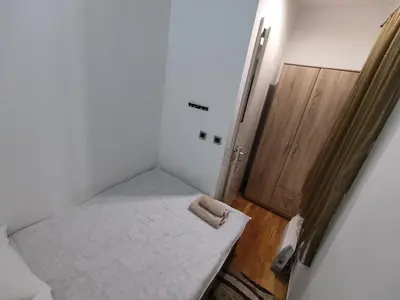 a small room with a bed and a wooden door at Obilic 22 Apartment in Belgrade