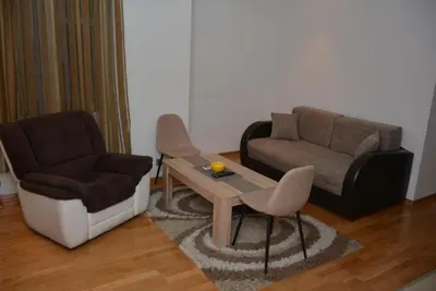 a living room with a couch and a table and a chair at Obilic 22 Apartment in Belgrade