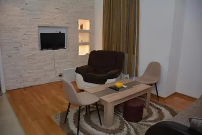 a living room with a chair and a table at Obilic 22 Apartment in Belgrade