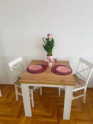 a wooden table with two plates and a plant on it at Belgradian 011 in Belgrade
