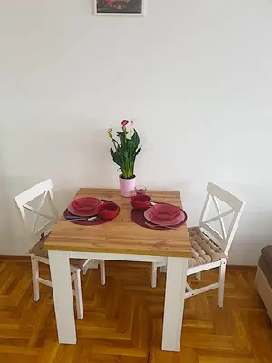 a wooden table with red plates and a plant on it at Belgradian 011 in Belgrade
