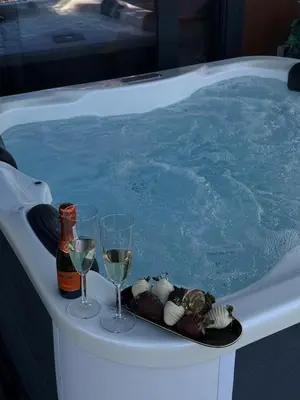 a hot tub with glasses of wine and a tray of food at ADA MOMENT Splav- kuca na reci Beograd- Floating House on SAVA RIVER ,Belgrade in Belgrade