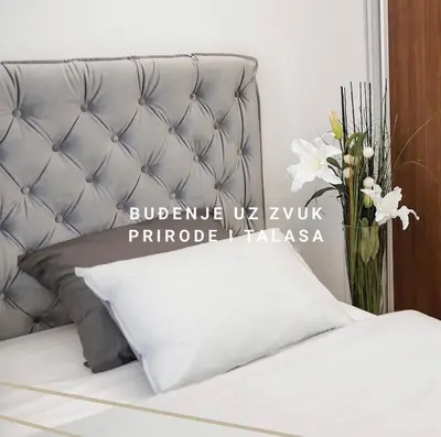 a bed with a white pillow and a vase of flowers at ADA MOMENT Splav- kuca na reci Beograd- Floating House on SAVA RIVER ,Belgrade in Belgrade