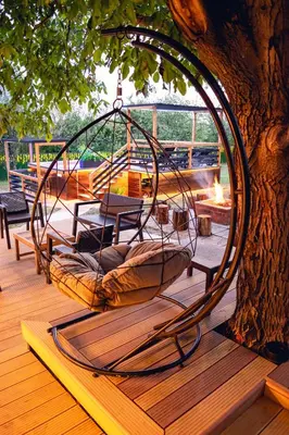 a metal swing sitting on a deck under a tree at Villa Dijana - Pool, Spa, Outdoor Kitchen in Belgrade