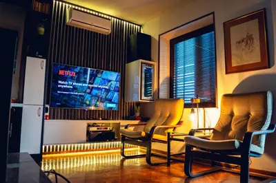 a living room with two chairs and a tv at Villa Dijana - Pool, Spa, Outdoor Kitchen in Belgrade