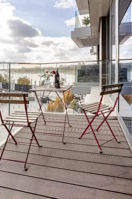 a table and two chairs on a balcony with a view at Belgrade Waterfront Luxury Appartment Pool & Gym in Belgrade